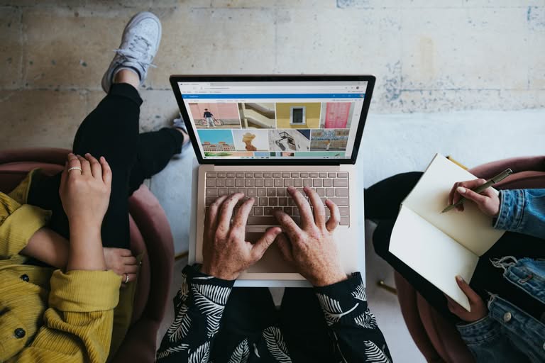 mains qui tapent sur un clavier d'ordinateur vu du dessus